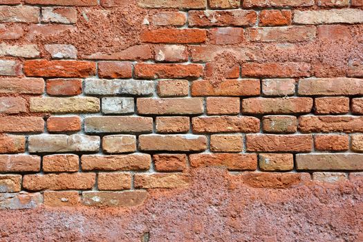 Red brick wall with saltpeter and moisture in Venice.