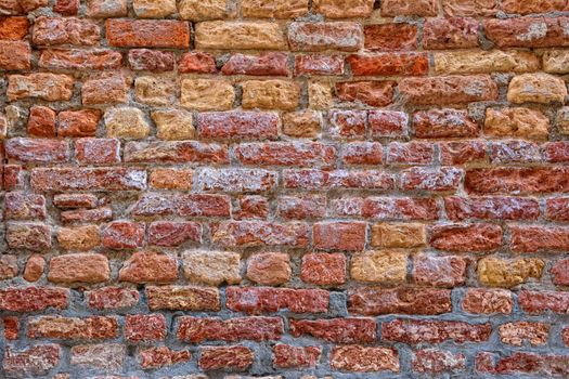 Red brick wall with saltpeter and moisture in Venice.