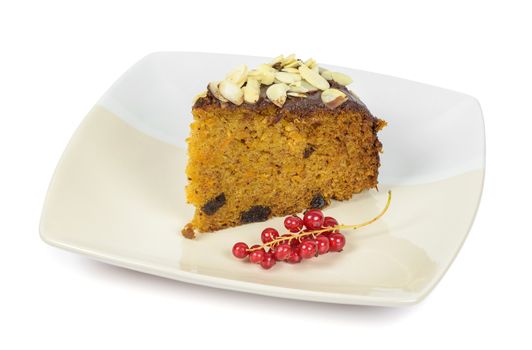 Carrot cake with almond flakes and red currant on a plate isolated on white background with clipping path