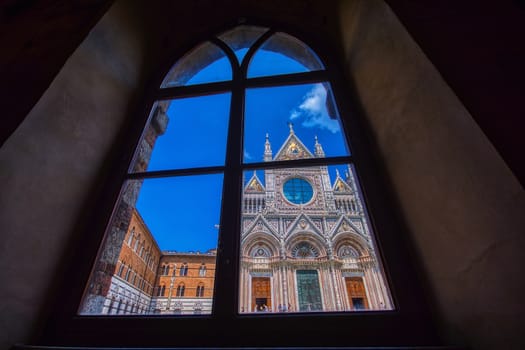 Siena, Italy - July 4, 2018: Facade Exterior Towers Mosaics Cathedral Church Siena Italy. Cathedral completed from 1215 to 1263.