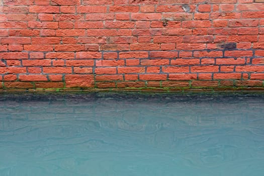 Canal in Venice with damp wall because of the high water.