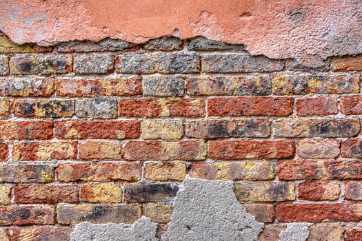 Old brick wall with peeling plaster, grunge background.