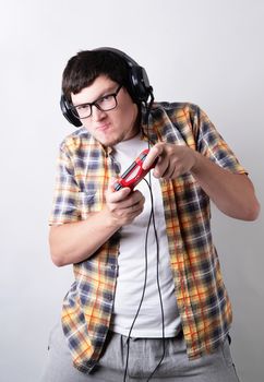 Stay home. Funny young man playing video games holding a joystick isolated on gray background