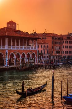 Venice, Italy - October 13, 2019: Beautiful view of traditional Gondola on famous Grand Canal in golden evening light at sunset in Venice, Italy.