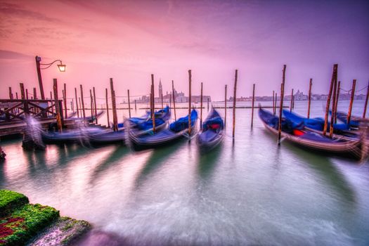 Gondolas moored by Saint Mark square on the Grand canals at dawn in Venice, Italy, Europe. Long exposure.