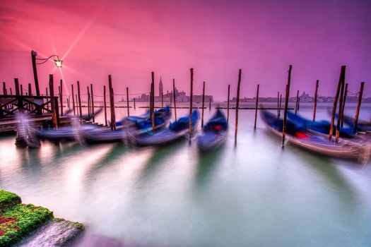 Gondolas moored by Saint Mark square on the Grand canals at dawn in Venice, Italy, Europe. Long exposure.