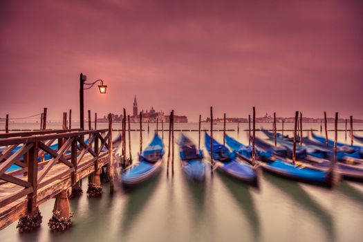 Gondolas moored by Saint Mark square on the Grand canal at dawn in Venice, Italy, Europe. Long exposure.