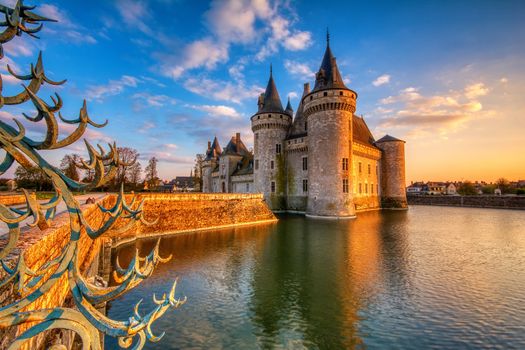 Sully Sur Loire, France - April 13, 2019: Famous medieval castle Sully sur Loire at sunset, Loire valley, France. The chateau dates from the end of the 14th century and is a prime example of medieval fortress.