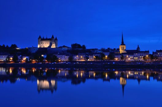 Panorama of Saumur at night with the medieval castle and the old town with Saint-Pierre church, Pays de la Loire, France.