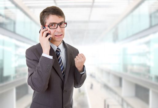 happy business man winning on the phone, at the office