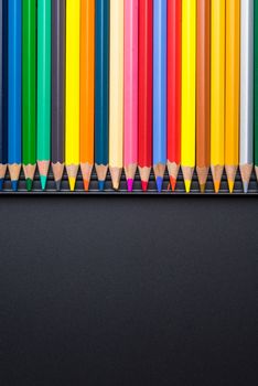 Color Pencils with plastic case isolated on Black Background close up. Colored style view top flat lay with free copy space for design or text. Back to school theme
