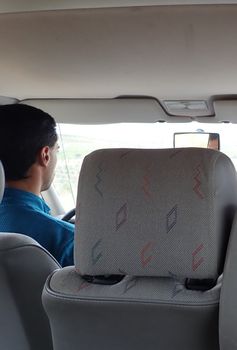 view from back of taxi or cab with car seat and driver