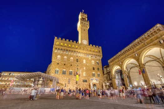 Florence, Italy - June 26, 2018 : View of the Palazzo Vecchio on the Piazza della Signoria with lots of visitors in Florence.
