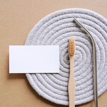 Flat lay branding identity business name card of sustainable products, stainless straw and bamboo toothbrush, minimal style