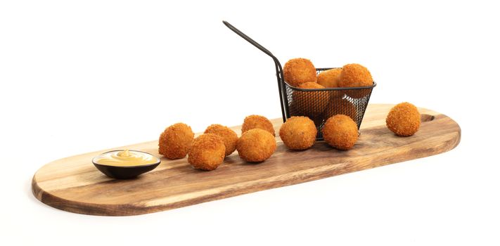 Dutch traditional snack bitterbal on a serving board, isolated