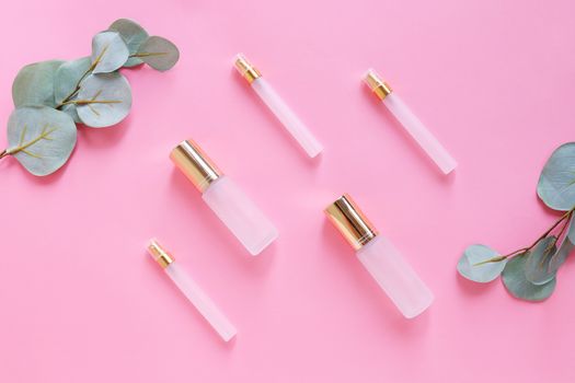 Flat lay of beauty skincare products for mock up in minimal style with plant on pink background