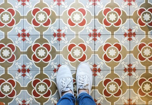 Top view selfie of feet in sneakers shoes on the vintage seamless floor background with copy space