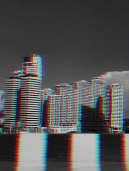 View of modern buildings from the street in the city background with glitch effect