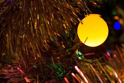 Closeup of yellow Christmas tree lamp as background