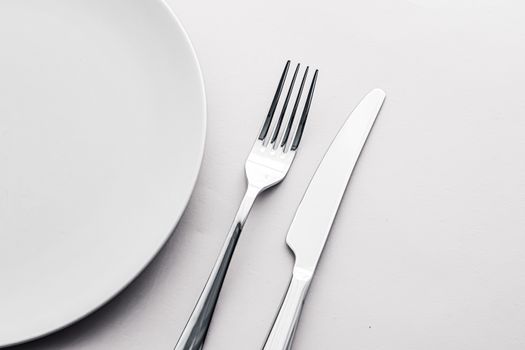 Empty plate and cutlery as mockup set on white background, top tableware for chef table decor and menu branding design