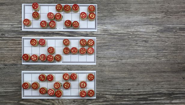 Playing the lottery, lotto, bingo and gambling money. lottery and gambling.win big money.Lotto game. Cards bingo. Wooden lotto barrels and game cards. Top view. Traditional game of bingo.