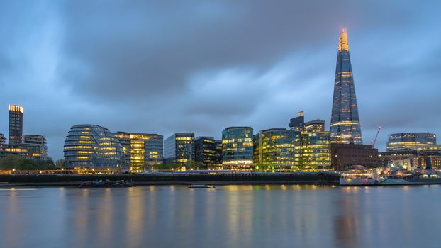 Colorful London skyline over River Thames at dusk on a cloudy day, United Kingdom