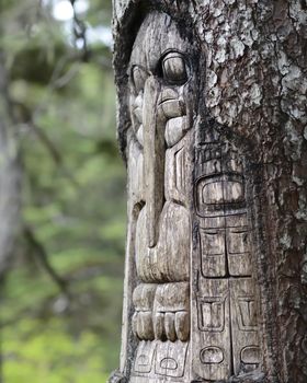 Wood Totem Pole carved by native Tlingit indians along a trail on top of Mt. Roberts in Juneau, Alaska, USA