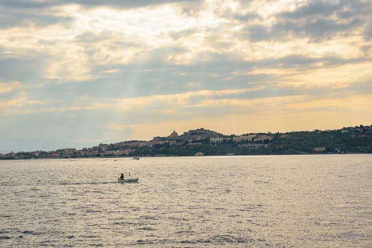 View of Milazzo town from the sea at sunset, Sicily, Italy