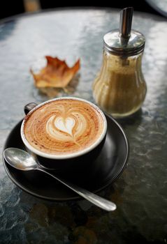 Hot cup of coffee latte and flat white with autumn leaves on the table