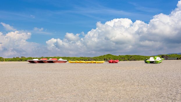 Pedalos and kayaks on a gravel beach at the Tyrrhenian Sea in Calabria, Italy