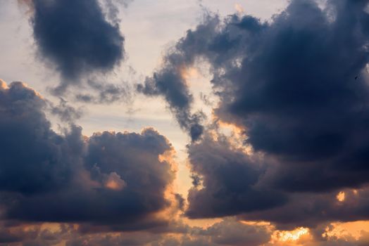 Dark clouds on the orange sky at sunset