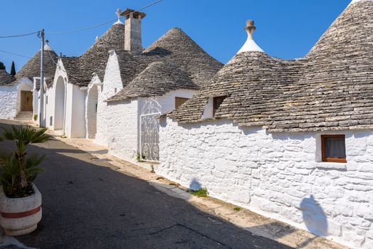 View of narrow picturesque street in Alberobello town, Apulia, Italy