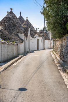 View of narrow picturesque street in Alberobello town, Apulia, Italy