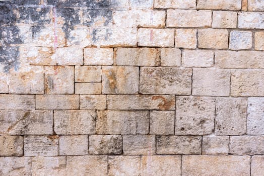 Background or texture made of brick wall with remains of plaster