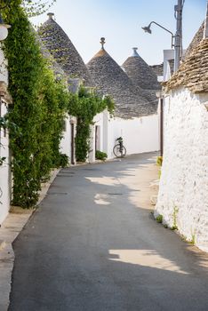 View of narrow picturesque street in Alberobello town, Apulia, Italy