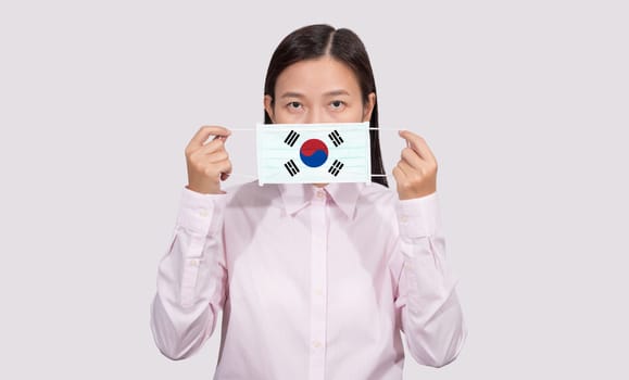 Asian woman wearing hygienic face mask painting South Korea flag to protect from the Coronavirus 2019 (COVID-19) infection outbreak situation, the virus originated from Wuhan, China.