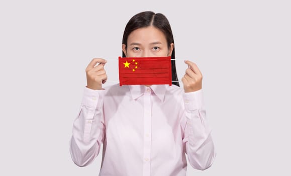 Asian woman wearing hygienic mask painting china flag to protect from the Coronavirus 2019 (COVID-19) infection outbreak situation, the virus originated from Wuhan, China. 