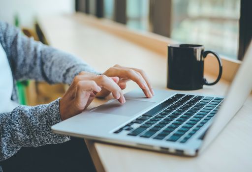 Close up of young businesswoman typing on computer laptop at the office or cafe