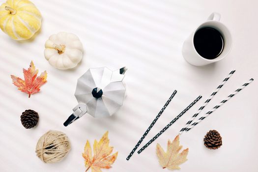 Flat lay of autumn or thanksgiving style concept with coffee, autumn leaves, pumpkins, moka pot and straw