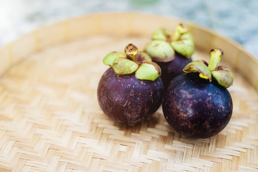 Mangosteen fruit on the wooden tray for food and eating concept