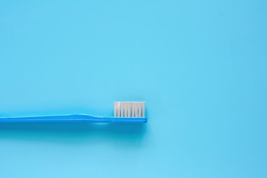 Toothbrush used for cleaning the teeth on blue background for dental care concept