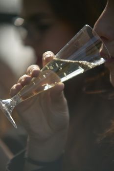 Woman Drinks the sparkling wine, close up image with blurred background