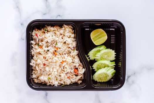 Delicious fried rice in lunch box on marble background for ready to eat and food concept