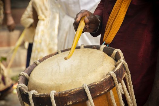 Close up of Hands performing Indian art form Chanda or chande cylindrical percussion drums playing during ceremony.