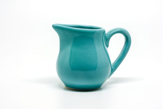 Green small ceramic pitcher on white background for utensil and dishware concept