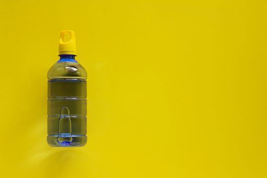 Water bottle on yellow background with copy space for healthy drinking concept