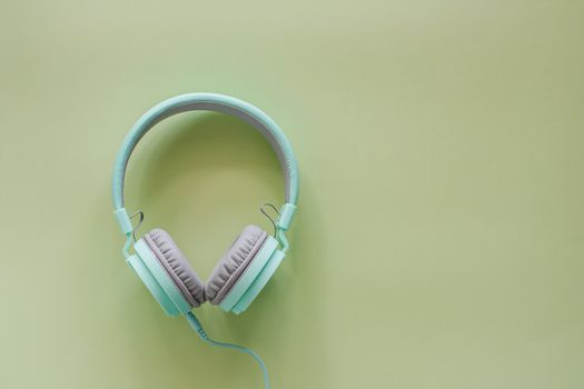 Headphones on green background for music and relaxation concept