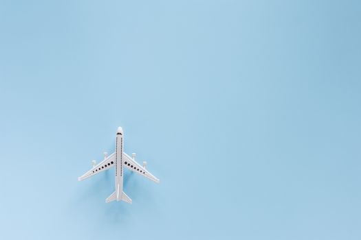 White airplane model on blue background for vehicle and transportation concept