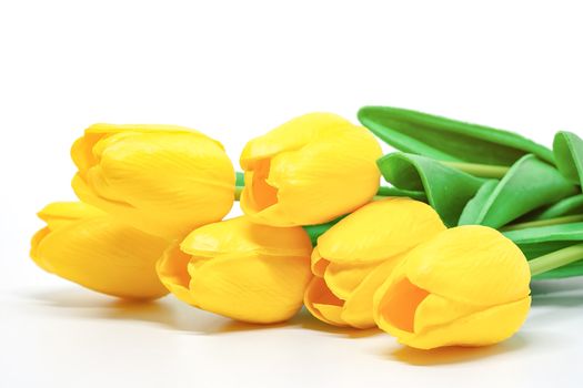 Artificial yellow tulips on white background for nature decoration and springtime concept