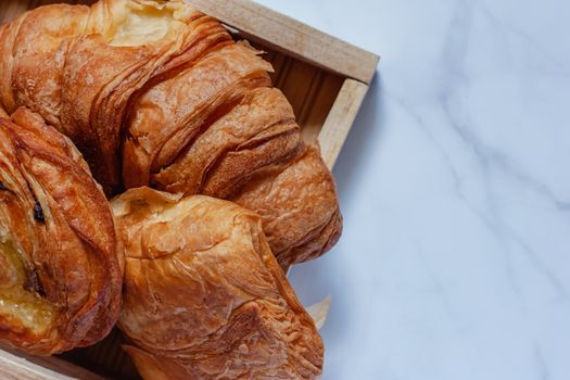 Top view of delicious bread on white marble background for food, bakery and eating concept